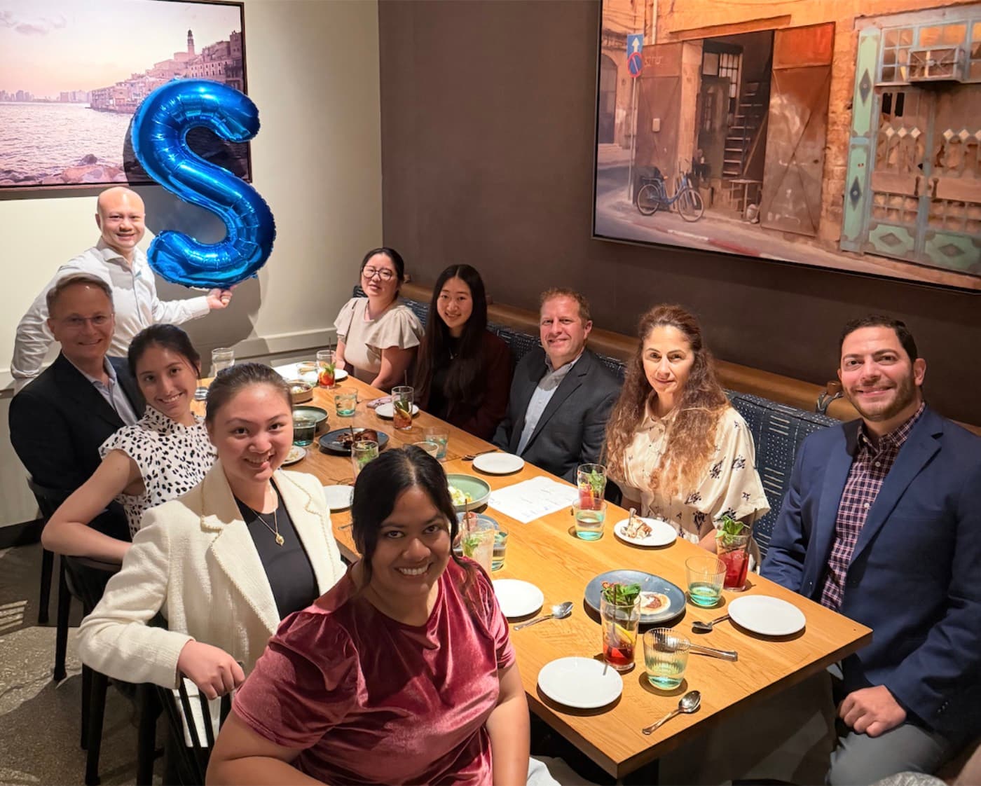 Oxus dinner in Chicago, guests beside a letter S balloon