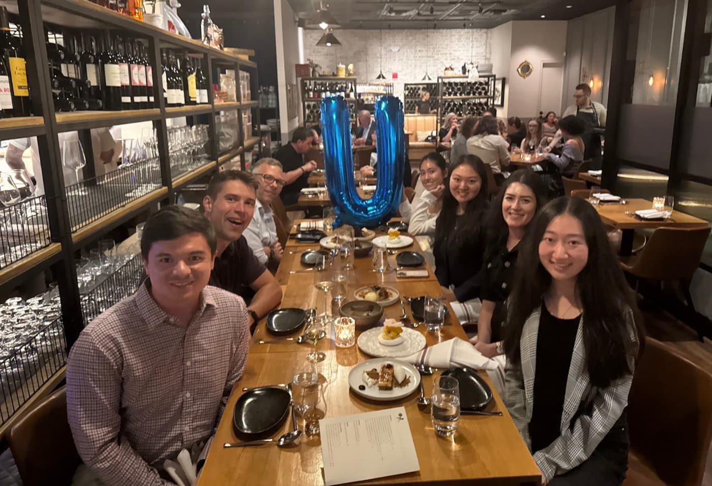 Oxus dinner in Washington, DC, guests beside a letter U balloon