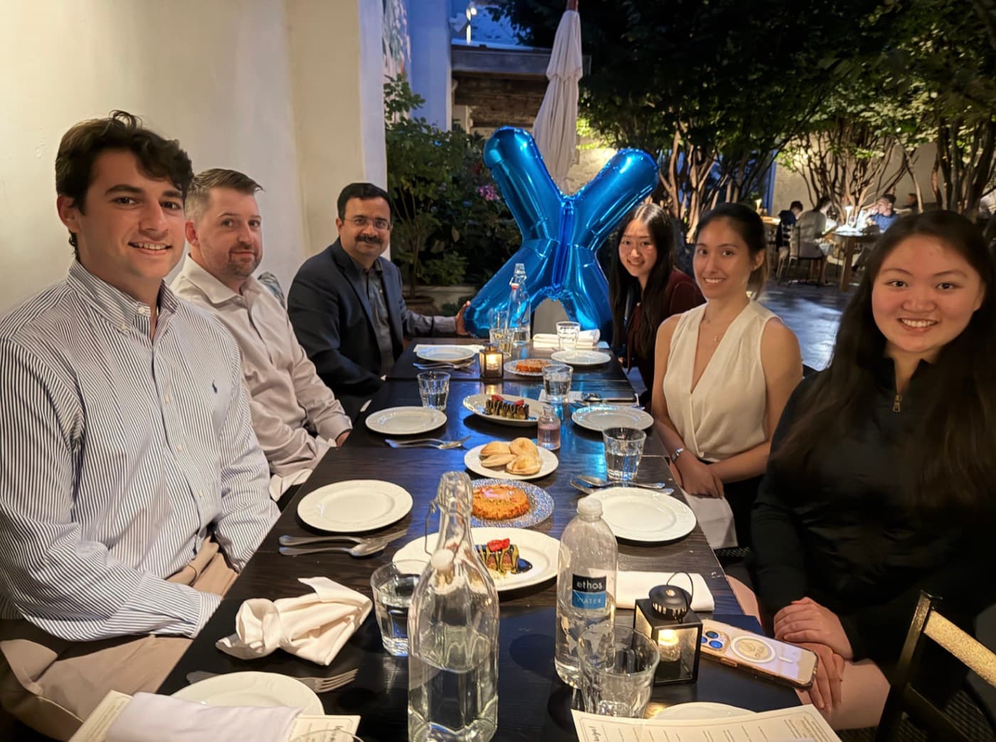 Oxus dinner in Philadelphia, guests beside a letter X balloon